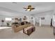 Bright living room with a ceiling fan, plush carpet, and a seamless flow to the dining and kitchen areas at 7707 W Diablo Dr, Las Vegas, NV 89113