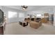 Bright living room with a ceiling fan, plush carpet, and a seamless flow to the dining and kitchen areas at 7707 W Diablo Dr, Las Vegas, NV 89113