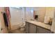 Well-lit bathroom with a shower-tub combination, gray vanity, granite counters and tiled flooring at 7910 Shimmery St, North Las Vegas, NV 89084