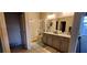 Spacious bathroom with double vanity, granite countertops, and a glass-enclosed shower at 7910 Shimmery St, North Las Vegas, NV 89084
