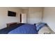 Comfortable bedroom with mounted television, closet with sliding doors, and neutral wall color at 7910 Shimmery St, North Las Vegas, NV 89084