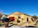 Charming single-story home with a red garage door, desert landscaping, and a blue sky above at 7910 Shimmery St, North Las Vegas, NV 89084