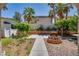 Outdoor space featuring a brick fire pit, lush greenery, trees, and a concrete walkway at 7917 Sally Irene Ct, Las Vegas, NV 89113