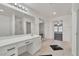 Bathroom featuring a vanity and mirrors, with an ensuite and closet entrance at 7917 Sally Irene Ct, Las Vegas, NV 89113