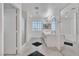 Bright bathroom with dual sinks, bathtub, shower, and black and white tile at 7917 Sally Irene Ct, Las Vegas, NV 89113