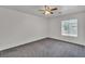 Bright bedroom featuring gray carpet, a ceiling fan, and natural light from a window at 7917 Sally Irene Ct, Las Vegas, NV 89113