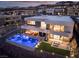 Aerial view of modern home featuring a sparkling pool, outdoor seating area, and beautiful mountain views at twilight at 801 Dragons Eye Dr, Henderson, NV 89012