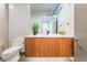 Modern powder room features a wood vanity, quartz countertop, and a decorative mirror at 801 Dragons Eye Dr, Henderson, NV 89012