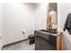 Contemporary half bathroom featuring black granite sink, toilet, and gray tile flooring at 801 Dragons Eye Dr, Henderson, NV 89012