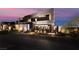 A modern home exterior showcasing its unique architectural design and front landscaping against a colorful sky at 801 Dragons Eye Dr, Henderson, NV 89012