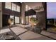 Contemporary home exterior with courtyard, pavers, gravel, desert landscaping, and architectural lighting at 801 Dragons Eye Dr, Henderson, NV 89012
