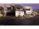 Modern home with a geometric design, landscaping, and a well-lit entrance at twilight at 801 Dragons Eye Dr, Henderson, NV 89012