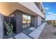 Modern home exterior featuring a stone walkway, xeriscaping, and a large sliding glass door at 801 Dragons Eye Dr, Henderson, NV 89012