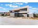 Modern home with clean lines, neutral palette, a wide driveway, and desert-style landscaping under a clear blue sky at 801 Dragons Eye Dr, Henderson, NV 89012