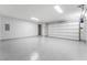 Clean, well-lit garage with a large roll-up door and epoxy flooring at 801 Dragons Eye Dr, Henderson, NV 89012