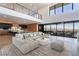 Spacious living room featuring floor-to-ceiling windows with panoramic views and stylish contemporary furnishings at 801 Dragons Eye Dr, Henderson, NV 89012