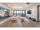 Spacious living room with a large window wall, modern lighting, and beautiful wood flooring at 801 Dragons Eye Dr, Henderson, NV 89012