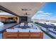 Outdoor living area with a fire pit, TV, mountain views, and seamless indoor-outdoor living at 801 Dragons Eye Dr, Henderson, NV 89012