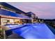A luxurious pool features integrated lounge chairs for relaxing, with stunning home and sunset views at 801 Dragons Eye Dr, Henderson, NV 89012