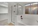 Bright bathroom featuring a tub, shower with glass door, and large window at 8024 Hurricane Cove Ct, Las Vegas, NV 89129