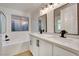 Bright bathroom showcases dual sinks, white cabinets, quartz counters, and framed mirrors at 8024 Hurricane Cove Ct, Las Vegas, NV 89129