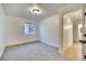 Bedroom features neutral carpet, a window and view of hallway to bathroom at 8024 Hurricane Cove Ct, Las Vegas, NV 89129