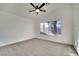 Carpeted bedroom with neutral walls, large window providing natural light and ceiling fan at 8024 Hurricane Cove Ct, Las Vegas, NV 89129