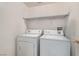 Laundry room with a white washer and dryer and wire shelving at 8250 N Grand Canyon Dr # 2102, Las Vegas, NV 89166