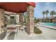 Outdoor seating area near a pool, featuring a covered patio with stone columns at 8250 N Grand Canyon Dr # 2102, Las Vegas, NV 89166