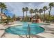 Community pool featuring rock waterfall, lush landscaping, lounge chairs, and palm trees at 8250 N Grand Canyon Dr # 2102, Las Vegas, NV 89166