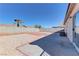 Spacious backyard with a gravel landscape, mature trees, and block wall at 832 Vineyard Vine Way, North Las Vegas, NV 89032