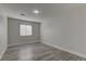 Bedroom features a neutral wall color, window with blinds, wood-look flooring, and overhead lighting at 832 Vineyard Vine Way, North Las Vegas, NV 89032