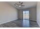 Neutral bedroom with a ceiling fan, sliding glass doors to the backyard, and wood-look flooring at 832 Vineyard Vine Way, North Las Vegas, NV 89032