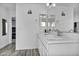 Bright bathroom features dual sinks, modern mirrors, white cabinetry and wood-look tile flooring at 854 Earth Luster Rd, Las Vegas, NV 89178