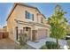 A two-story home with a two-car garage with stone accents and easy to care for desert landscaping at 854 Earth Luster Rd, Las Vegas, NV 89178