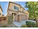 A beautiful two-story home with a two-car garage with stone accents and desert landscaping at 854 Earth Luster Rd, Las Vegas, NV 89178