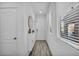 Bright hallway featuring modern decor, white walls, wood-look tile flooring, and plenty of natural light from a window at 854 Earth Luster Rd, Las Vegas, NV 89178