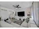 Bright living room with a modern ceiling fan, large television, and comfortable white sectional sofa at 854 Earth Luster Rd, Las Vegas, NV 89178