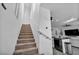 Carpeted staircase leading to a living area featuring modern lighting, stainless appliances, and sleek black countertops at 854 Earth Luster Rd, Las Vegas, NV 89178