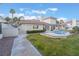 View of the home's backyard with the pool, patio, and green lawn at 8701 Robinson Ridge Dr, Las Vegas, NV 89117