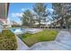 View of the backyard featuring a lush green lawn, swimming pool and manicured landscaping at 8701 Robinson Ridge Dr, Las Vegas, NV 89117