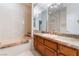 Bathroom featuring a large tub, marble countertops, wood cabinets and a mirrored wall at 8701 Robinson Ridge Dr, Las Vegas, NV 89117