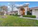 Inviting home with arched entryway, manicured hedges, and a lush green lawn at 8701 Robinson Ridge Dr, Las Vegas, NV 89117