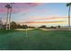 Golf course putting green with a flag, palm trees and a colorful sunset at 8701 Robinson Ridge Dr, Las Vegas, NV 89117