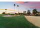 Beautiful golf course view featuring tall palm trees, green fairway and a vibrant sunset sky at 8701 Robinson Ridge Dr, Las Vegas, NV 89117