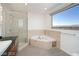 Bright bathroom featuring a soaking tub, glass shower, and large window with city views at 900 Las Vegas Blvd # 804, Las Vegas, NV 89101