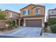 Two-story home featuring a 2-car garage, desert landscaping, and a charming, covered front entryway at 10139 Palazzo Marcelli Ct, Las Vegas, NV 89147