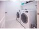 Functional laundry room with a new-looking washer and dryer and clean white tiles at 10139 Palazzo Marcelli Ct, Las Vegas, NV 89147