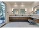 Bright bathroom with a double vanity, modern mirrors, and a sliding glass door to an outdoor patio at 10313 Orkiney Dr, Las Vegas, NV 89144