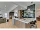 Modern kitchen with marble countertops, wooden cabinetry, pendant lights, and a cozy breakfast bar with seating at 10313 Orkiney Dr, Las Vegas, NV 89144